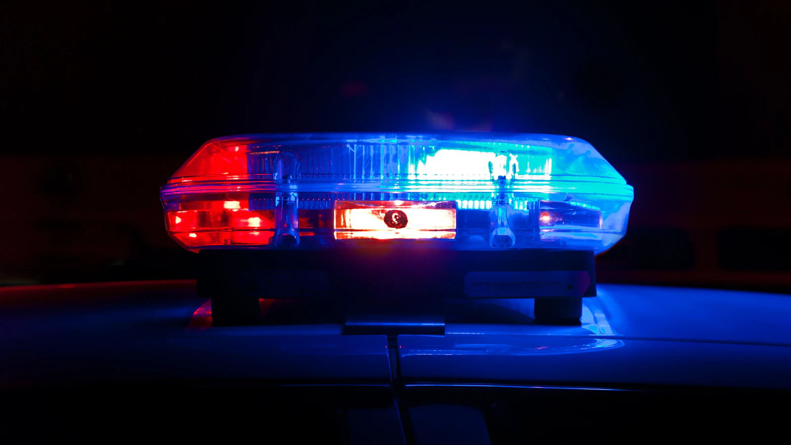 Police light bar flashing red and blue at night — Oklahoma City DWI lawyer