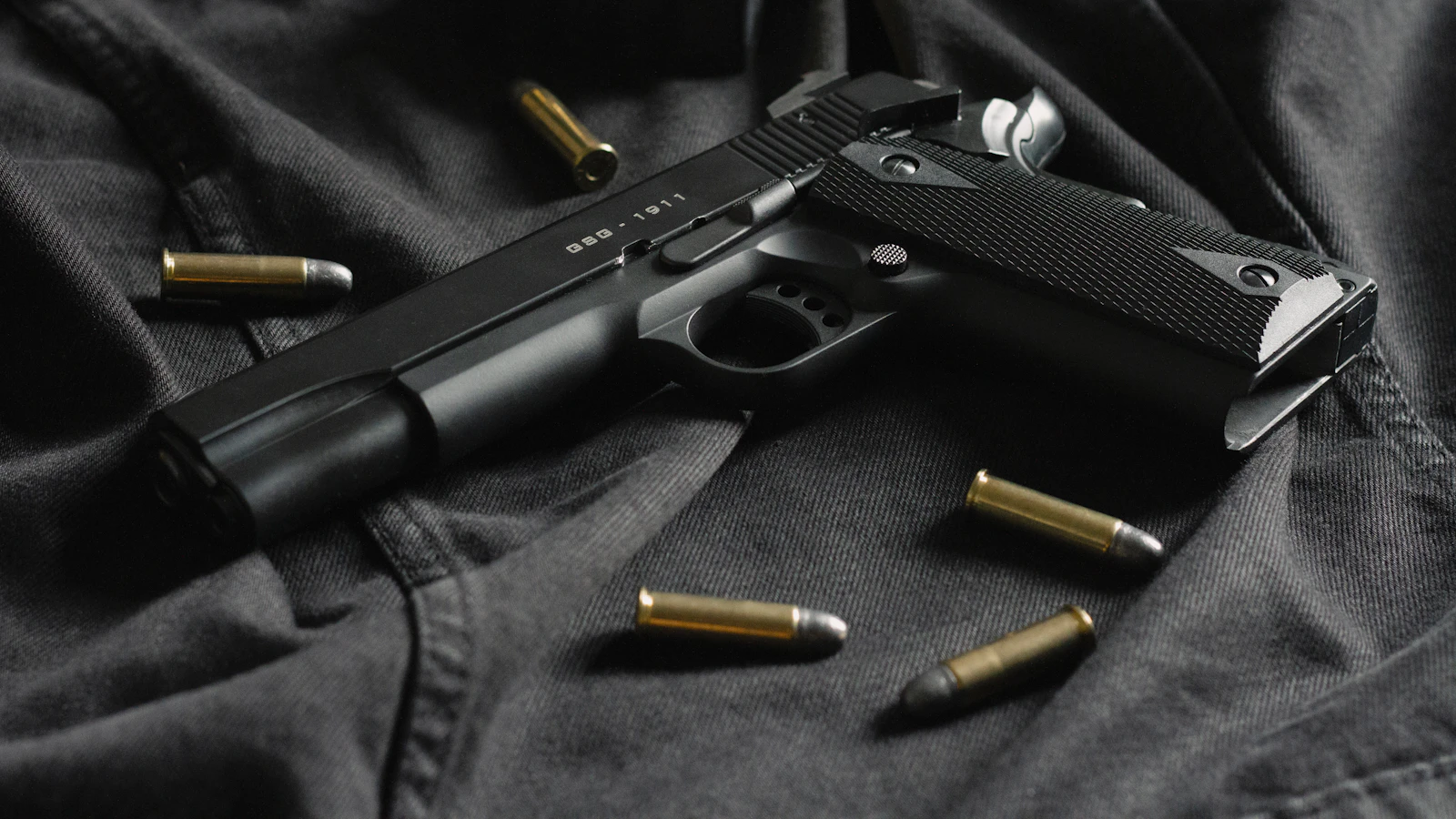 Black semi-automatic pistol on dark fabric — Oklahoma City gun charges lawyer