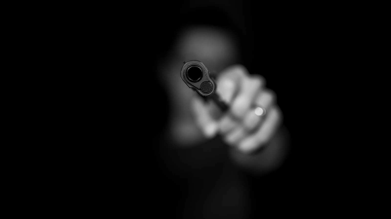 Black and white photo of a person holding a handgun — Pointing a firearm in Oklahoma